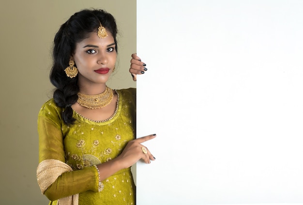 Traditional Girl holding and showing blank white sign board