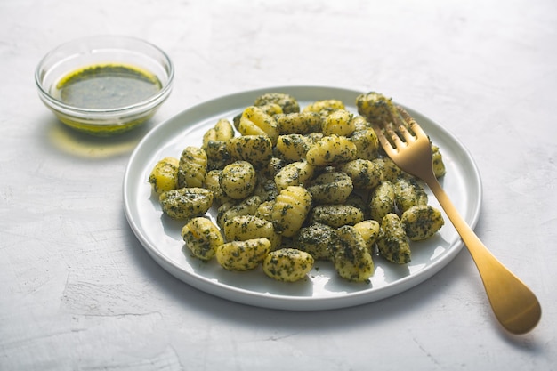 Traditional gnocchi with pesto sauce on gray concrete background It prepared with potato