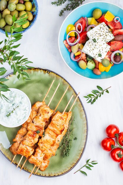 Souvlaki di spiedini di pollo tradizionali greci con salsa tzatzikiiki