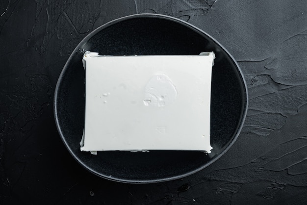 Traditional greek feta cheese set, on black table, top view