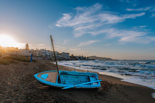 ギリシャのクレタ島の夕暮れ時の海岸にある伝統的なギリシャの漁船