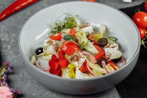 Traditional greek salad with fresh vegetables, feta cheese and olives.