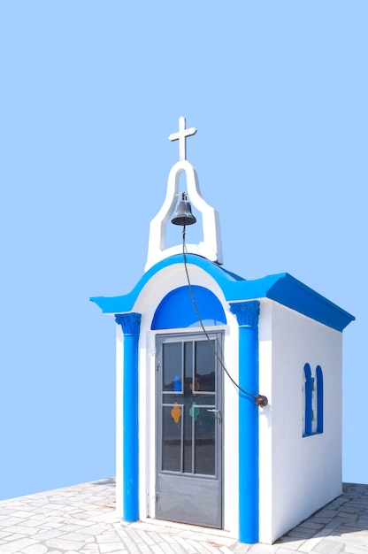 Traditional greek small church in blue and white style on a\
blue background in greece