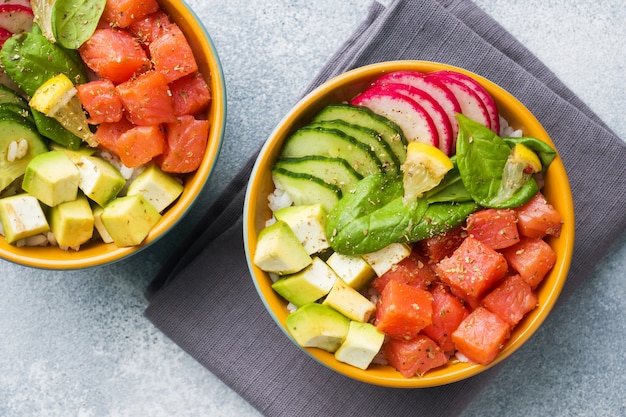 Traditional Hawaiian Poke salad with salmon, avocado rice and vegetables in a bowl