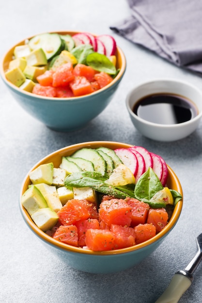 Traditional Hawaiian Poke salad with salmon, avocado rice and vegetables in a bowl 