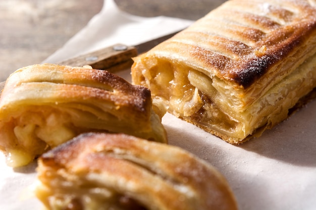 Traditional homelose upmade apple strudel on wooden table. 