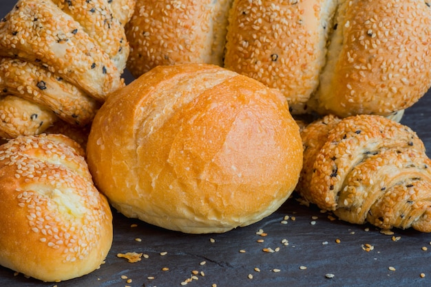 Traditional homemade bakery bread with sesame, Stack of fresh bread on stone table