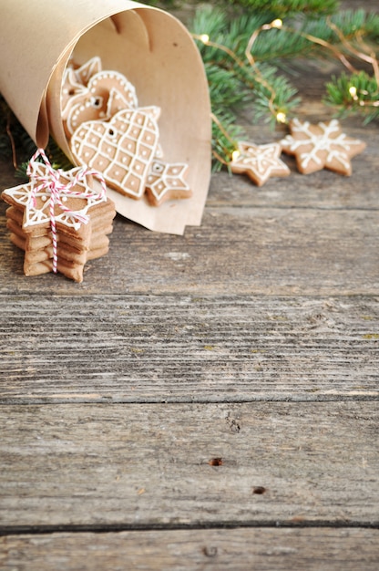 Traditional homemade Christmas gingerbread sugar frosting in paper envelope on wooden. 