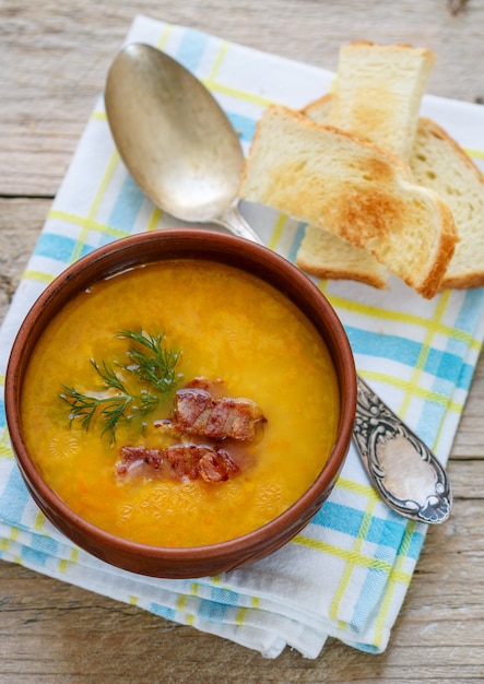 Traditional homemade  pea soup with bacon, herbs and croutons. Rustic style