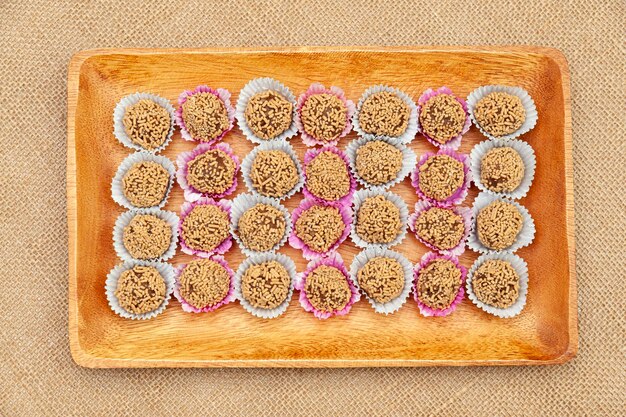 Traditional homemade sweets known in Brazil as Brigadeiro de Amendoim on a wooden tray