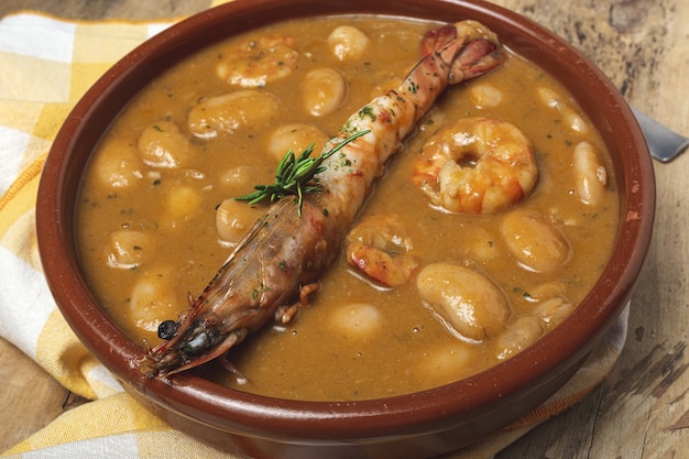 Traditional Homemade White Bean Stew with Prawns. Typical Spanish food. on wooden table