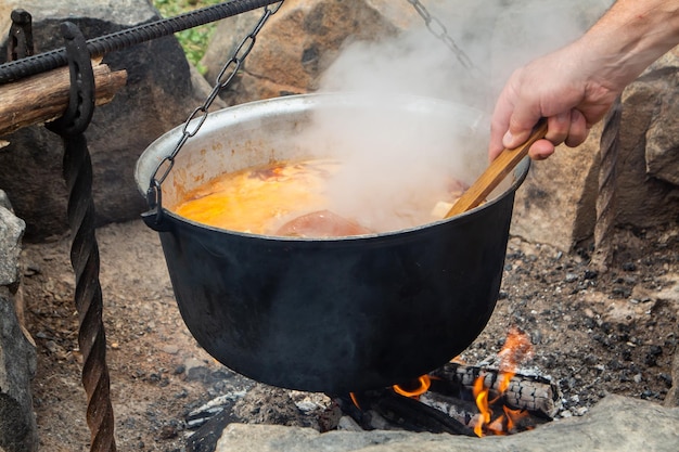 Traditional Hungarian bograch Cooking on an open fire Traditional Hungarian goulash in a cauldron Transcarpathian dish Soup with meat and chili pepper