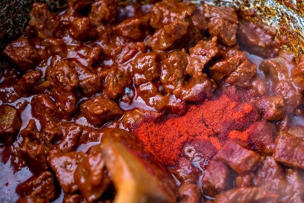 traditional hungarian goulash is boiling in a cauldron