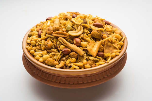 Piatto salato fritto nel grasso bollente tradizionale indiano - chivda o miscela o farsan o farsaan fatta di farina di ceci e mescolata con frutta secca servita in una ciotola o piatto