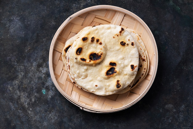 대나무 쟁반 위에 전통적인 인도 Flatbread Chapati. 쉬운 가정 요리 개념. 평면도. 플랫 레이.