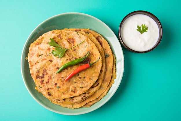 전통적인 인도 음식 Aloo paratha 또는 감자 박제 납작한 빵. 다채로운 또는 나무 배경 위에 토마토 케첩과 커드와 함께 제공됩니다. 선택적 초점