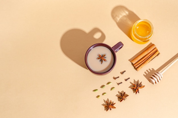 Traditional Indian tea. Masala tea in a dark clay cup with ingredients, hard shadows