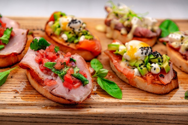 Traditional italian antipasto bruschetta appetizer with meat fish greens and balsamic vinegar