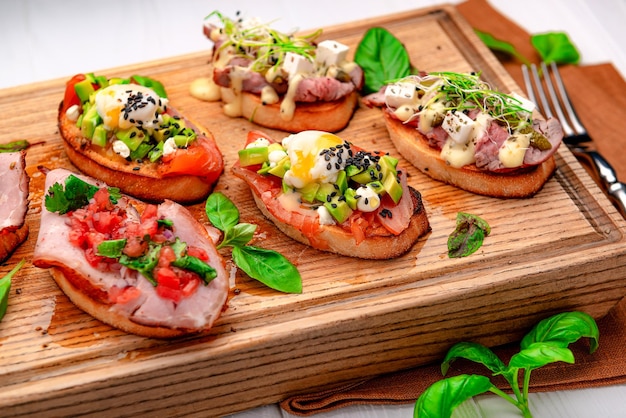 Traditional italian antipasto bruschetta appetizer with meat fish greens and balsamic vinegar