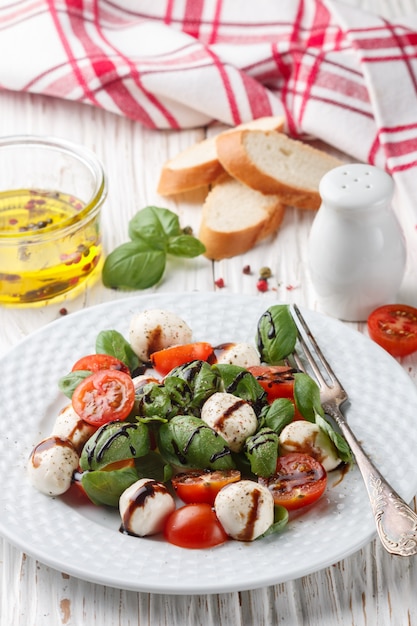 Traditional Italian Caprese salad with mozzarella, cherry tomatoes, 