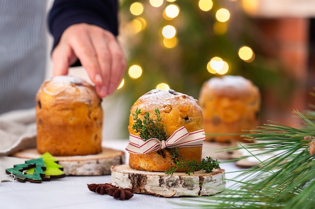 お祝いの休日の装飾が施された素朴なテーブルの上の伝統的なイタリアのクリスマスケーキパネトーネ