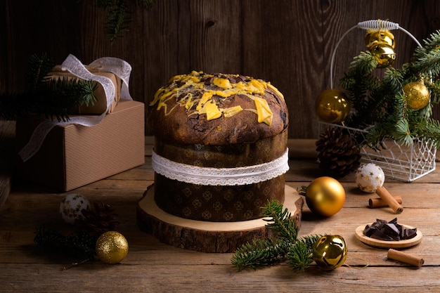 Traditional italian christmas cake panettone with white ribbon and festive decoration on wooden