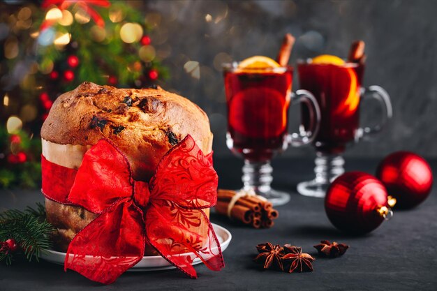 Traditional italian christmas panettone cake with dried fruits decorated with a red ribbon bow