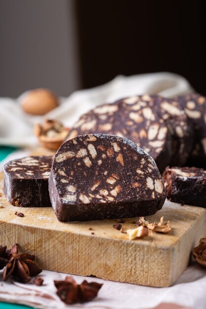 Traditional Italian dessert - christmas chocolate salami with broken biscuits and walnuts on a table