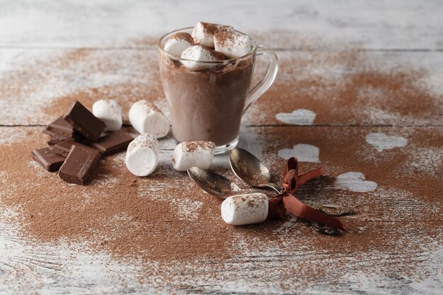 Traditional Italian dessert tiramisu decorated with cocoa. On a white table the heart of the cocoa