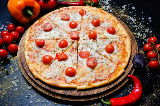 伝統的なイタリア料理。溶けたチーズとチェリートマト、新鮮な野菜のピザ