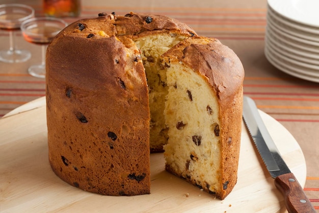 Traditional Italian panettone and a slice on a cutting board close up