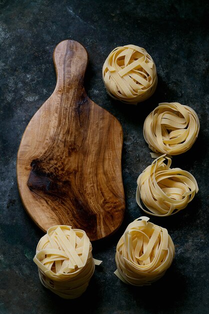 木の板と伝統的なイタリアのパスタタリアテッレ。フラットレイ。上面図