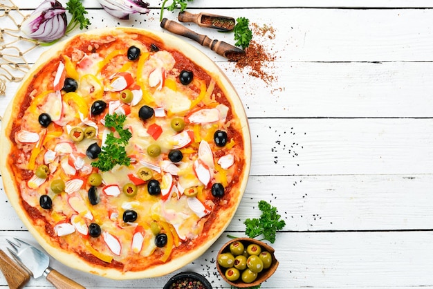 Traditional Italian pizza with crab sticks and olives Top view free space for your text Rustic style
