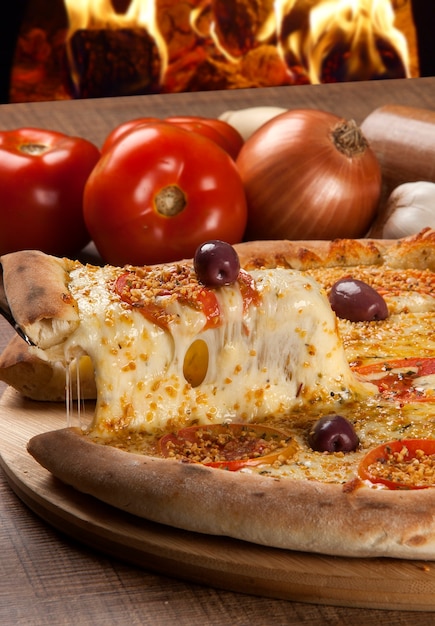 Traditional italian pizza with ingredients on wooden.