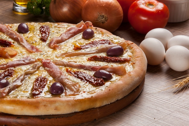 Traditional italian pizza with ingredients on wooden.