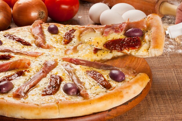 Traditional italian pizza with ingredients on wooden.