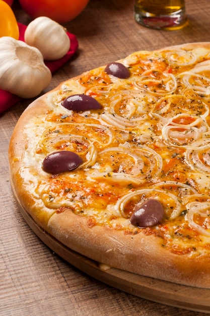 Traditional italian pizza with ingredients on wooden.