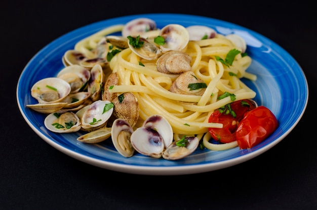 Traditional italian seafood concept. Spaghetti with clams or shelfish, tomato and herbs