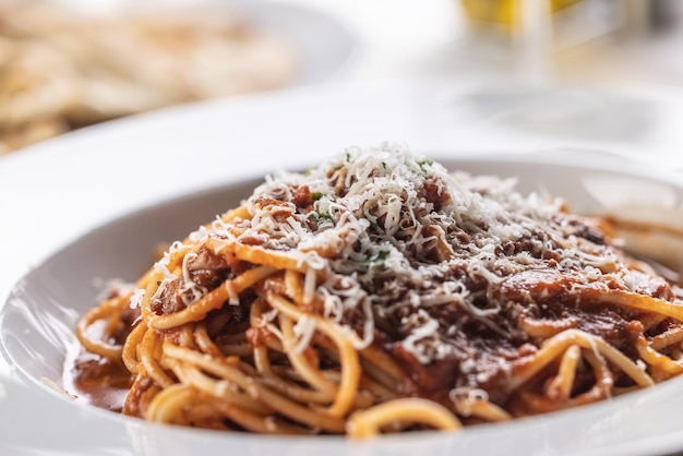 Foto spaghetti tradizionali italiani con salsa rossa cosparsi di parmigiano appena grattugiato