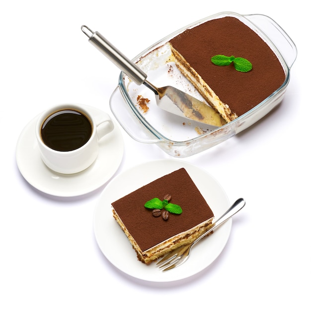 Traditional italian tiramisu dessert in glass baking dish portion on plate and cup of coffee isolatet on white