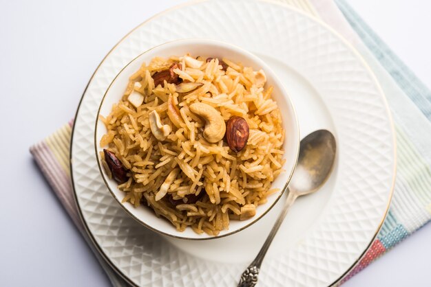 Traditional Jaggery Rice or Gur wale chawal in Hindi, served in a bowl with spoon. selective focus