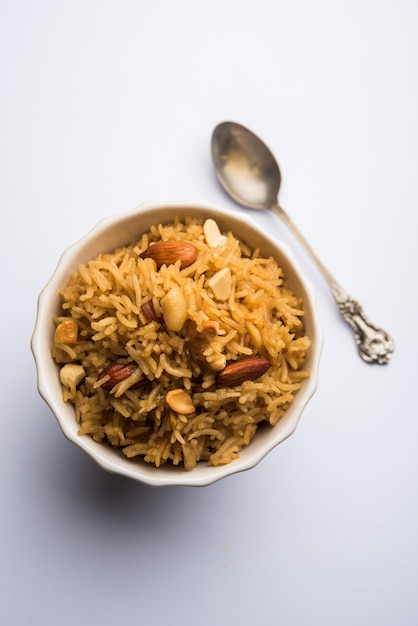 Traditional Jaggery Rice or Gur wale chawal in Hindi, served in a bowl with spoon. selective focus