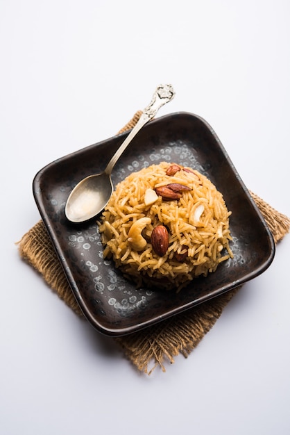 Traditional Jaggery Rice or Gur wale chawal in Hindi, served in a bowl with spoon. selective focus