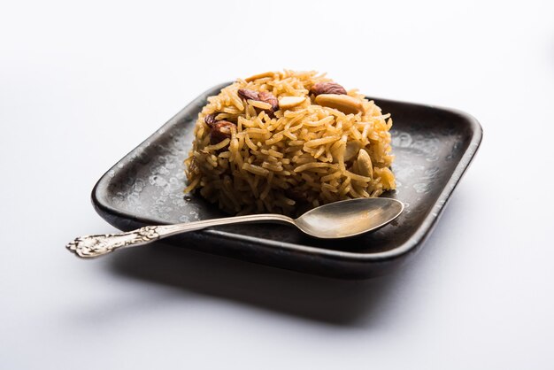 Traditional Jaggery Rice or Gur wale chawal in Hindi, served in a bowl with spoon. selective focus