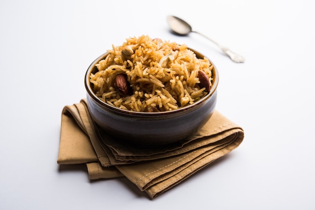 Traditional Jaggery Rice or Gur wale chawal in Hindi, served in a bowl with spoon. selective focus