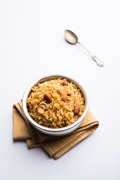 Traditional Jaggery Rice or Gur wale chawal in Hindi, served in a bowl with spoon. selective focus