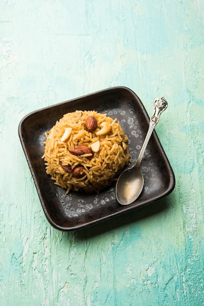 Traditional Jaggery Rice or Gur wale chawal in Hindi, served in a bowl with spoon. selective focus