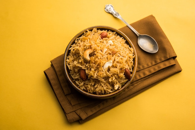 Традиционный рис джаггери или чавал Gur wale на хинди, подается в миске с ложкой. выборочный фокус