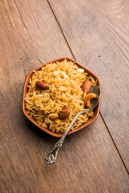 Traditional Jaggery Rice or Gur wale chawal in Hindi, served in a bowl with spoon. selective focus