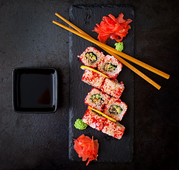 Traditional Japanese food - sushi, rolls and sauce on a black background. Top view